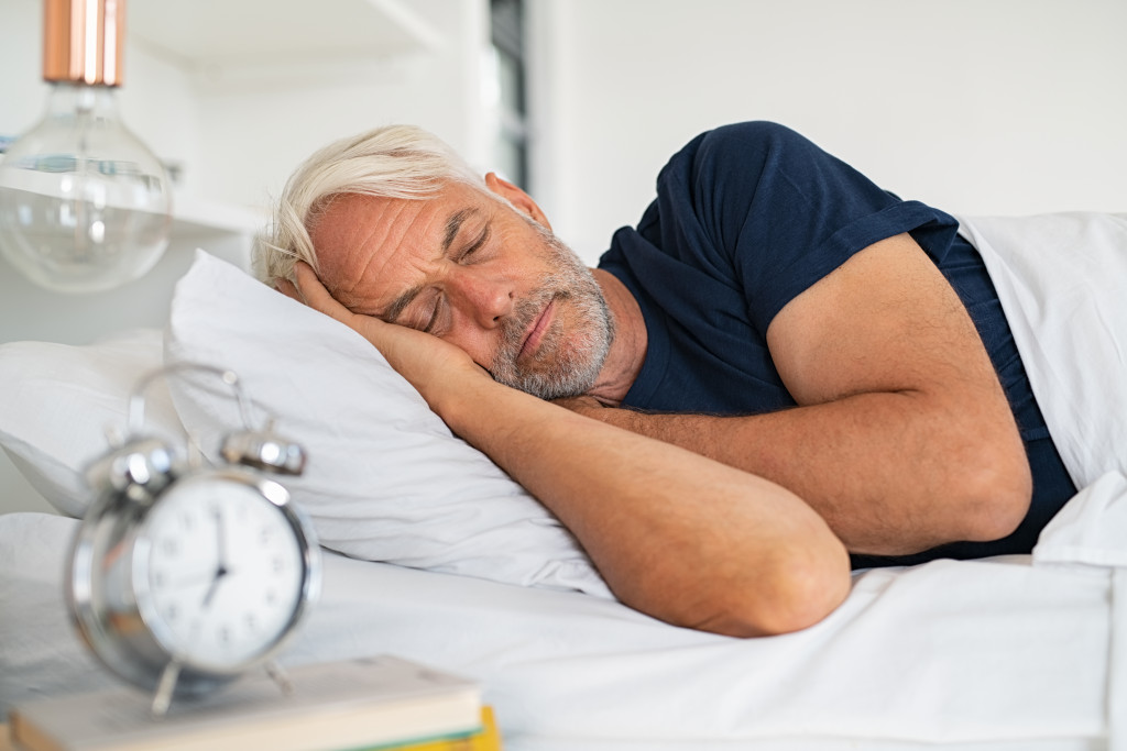 Mature man sleeping on a bed.